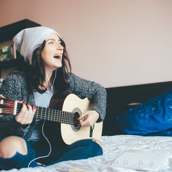 Young beautiful middle eastern woman sitting bedroom indoors at home - aspiring, learning, creativity concept